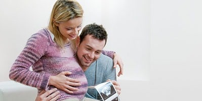 A couple looking at images of a private dating baby scan in London